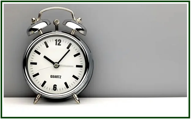 A retro chrome alarm clock on a grey background, symbolizing time management and the limits of personal action.